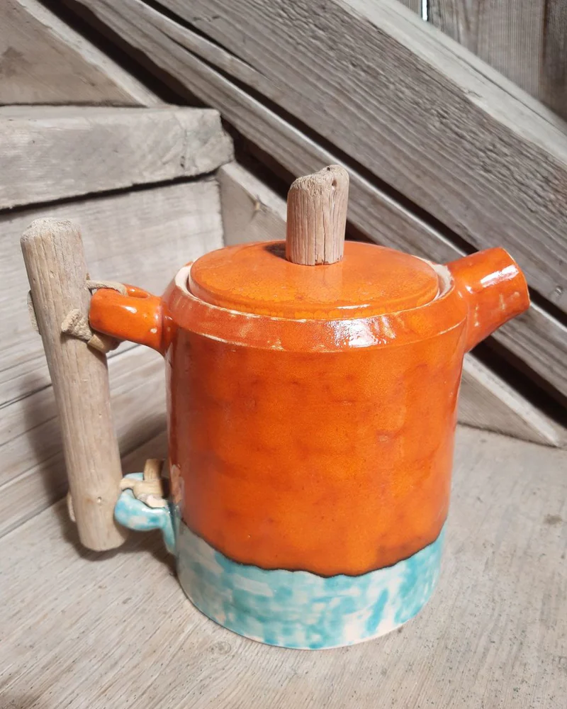 Оранжевый чайник с ручкой из коряжки