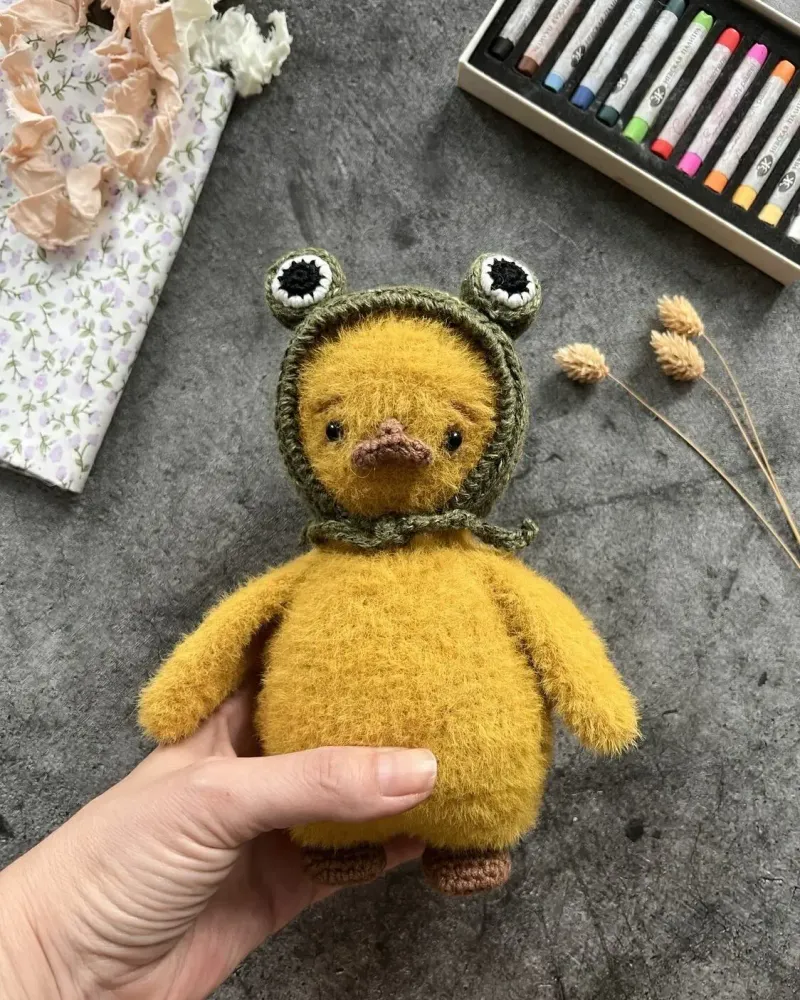 Вязаная игрушка «Утёнок в шапочке-лягушке»