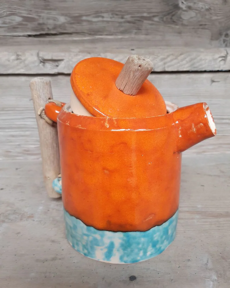 Оранжевый чайник с ручкой из коряжки