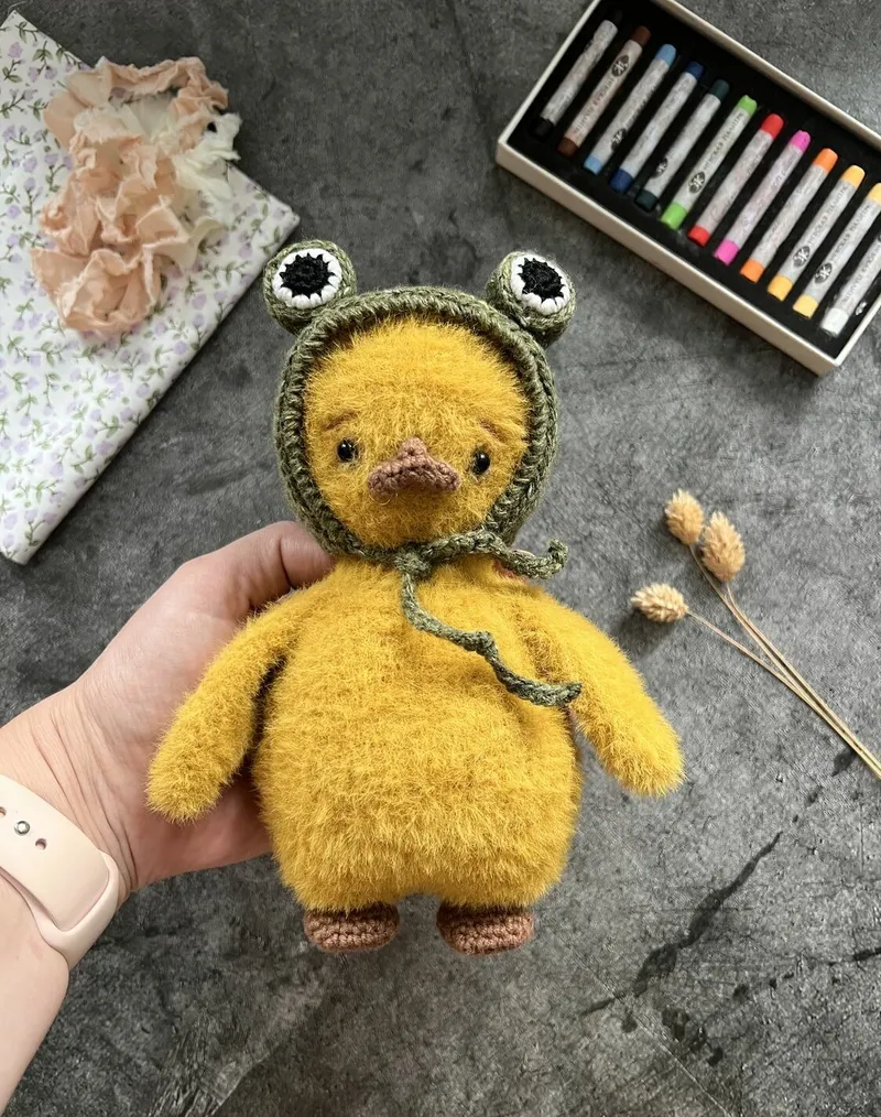 Вязаная игрушка «Утёнок в шапочке-лягушке»